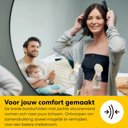 Moeder draagt de discrete Medela Freestyle Mini handsfree opvangcup onopvallend onder haar kleding.
